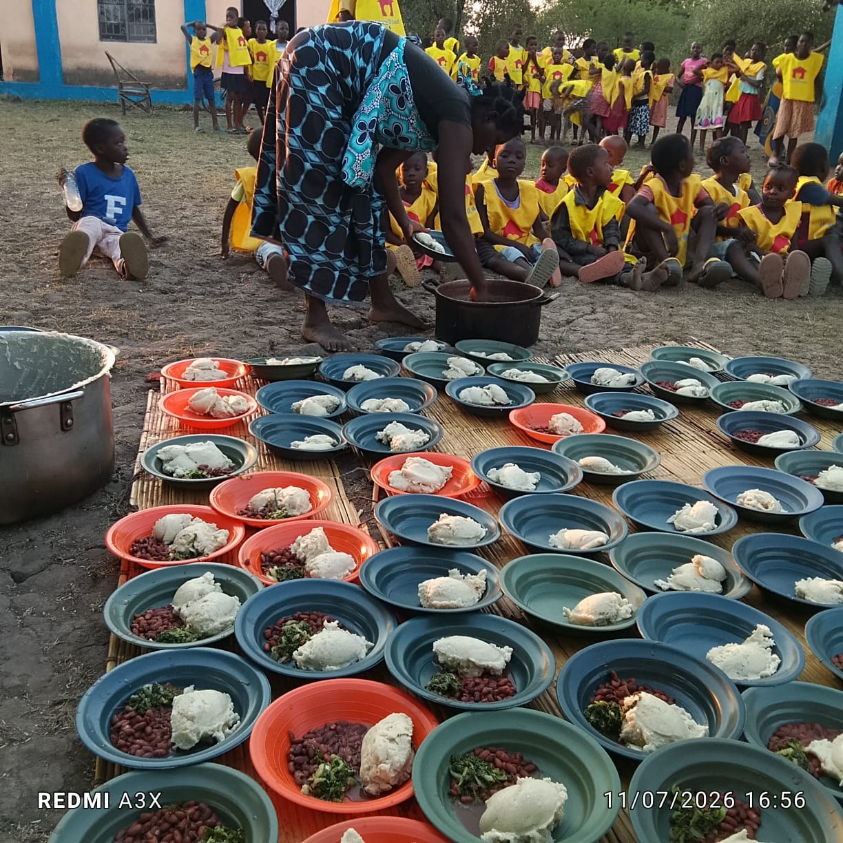 Voluntária servindo pratos de comida para as crianças